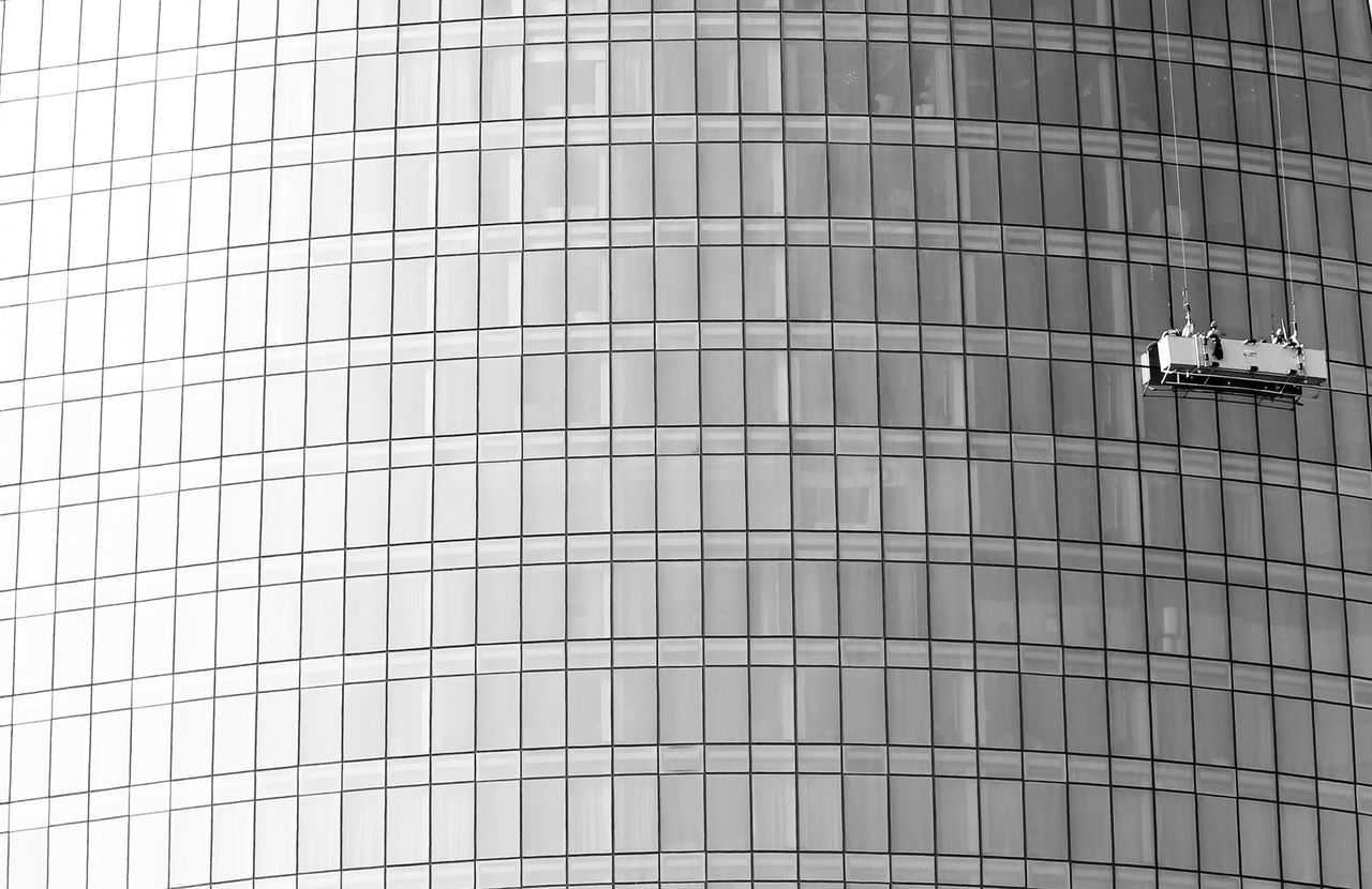 Façade vitrée de grande hauteur avec plateforme suspendue pour le nettoyage des vitres.