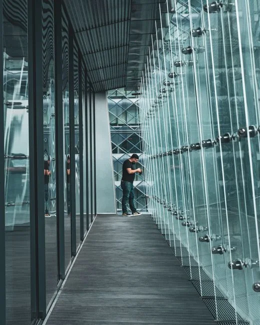 Two workers hanging to clean windows on a modern skyscraper facade.